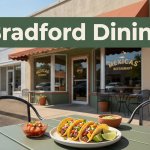 Tacos, salsa, and lime sit on an outdoor table before a sunny Bradford restaurant storefront.