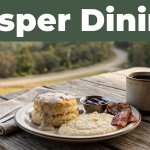 A Southern breakfast and coffee on a rustic café table with Ozark hills behind it.