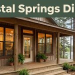 Rustic café with a wooden porch, glowing windows, and forested lake scenery.