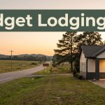 A quiet rural Alabama motel at golden hour with a warmly lit entrance and dark green banner.