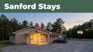 A quiet roadside motel in rural Alabama with a vacancy sign and parked car at dusk.