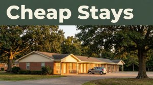 A modest motel with one car, oak trees, and a dark-green headline band at sunset.