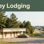 A quiet motel beside a rural Alabama highway with pine trees and a parked car.