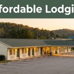 A charming motel near Woodland, Alabama glows warmly at golden hour beside wooded hills.