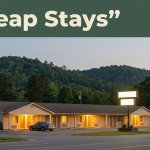 A warmly lit budget roadside motel at dusk with rolling hills behind it in Alabama.