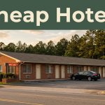 A modest roadside motel with a glowing vacancy sign during sunset.