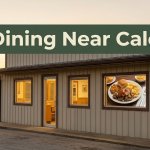 A small Arkansas diner with warm windows and a Southern meal visible inside at sunset.