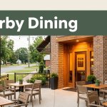 Warmly lit restaurant entrance with outdoor tables, greenery, and a Nearby Dining banner.