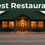 A Southern restaurant with glowing windows beside a quiet rural road at sunset.