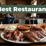 Barbecue platter with pulled pork, ribs, beans, and coleslaw on a wooden table.