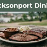 A barbecue plate with brisket, ribs, beans, and coleslaw sits on a wooden table.
