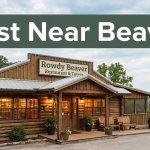Rustic Rowdy Beaver restaurant with glowing windows and Ozark scenery behind it.