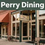 Historic brick restaurant entrance with The Perfect Pear sign in warm evening light.