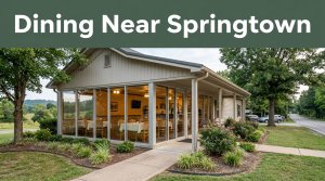 A welcoming restaurant exterior with warm windows, greenery, and a green “Dining Near Springtown” banner.