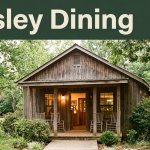 Rustic café with warm windows, a porch, and a welcoming entrance in leafy countryside.