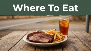 Barbecue, fries, and iced tea on a wooden table near a blurred highway.