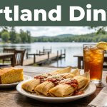 Tamales, cornbread, and iced tea on a rustic table at a lakeside café.