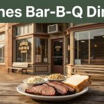 A historic brick diner behind a plate of sliced barbecue meat.