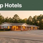 A modest motel glows beside a quiet Alabama road at sunset.