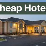 A budget hotel exterior in Ozark, Alabama, glows beside a tidy parking lot at dusk.
