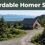 A cozy cabin overlooks Homer, evergreen hills, Kachemak Bay, and a winding road.