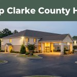 A modest roadside hotel in Jackson, Alabama, warmly lit beside a landscaped parking area.