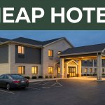 A budget hotel entrance at dusk with one parked car and highway lights.