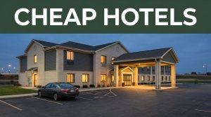 A budget hotel entrance at dusk with one parked car and highway lights.