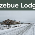 A small Kotzebue hotel beside a snowy road under a gray Arctic sky.