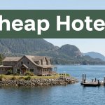 A waterfront lodge overlooks blue water, mountains, and a ferry dock beneath a Cheap Hotels banner.