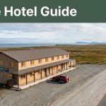 A roadside inn with warm windows, a rental car, tundra, and the Bering Sea under a Nome Hotel Guide banner.