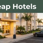 Affordable hotel exterior with a car, suitcase, harbor, and cruise ship at sunset.