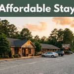 A roadside motel with parked cars, pine trees, and a highway in Alabama.