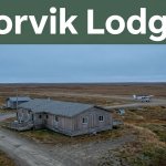 A Noorvik lodging house beside tundra, low buildings, and a distant bush plane.