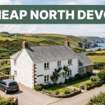 A welcoming guesthouse and car sit beneath green hills near the North Devon coast.
