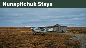 A bush plane beside a cabin on flat Alaska tundra beneath a slate-blue sky.