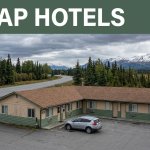 A roadside motel and parked car near Alaska mountains and open tundra.