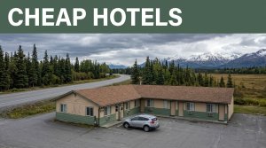 A roadside motel and parked car near Alaska mountains and open tundra.