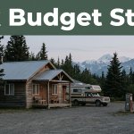 A roadside cabin, travel vehicle, fuel sign, and spruce trees near Tok, Alaska.
