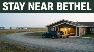 A small Bethel motel entrance beside a gravel road and tundra.