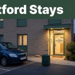 A modest hotel entrance with a car and suitcase beneath a dark green headline band.