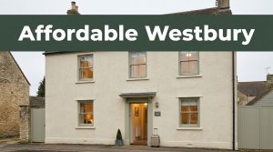 A welcoming Westbury B&B townhouse with warm windows and a suitcase by the entrance.