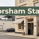 A Horsham hotel entrance beside a station approach, with a suitcase and parked car.