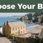 A seaside hotel overlooks cliffs, blue sea, and a sandy beach in North Devon.