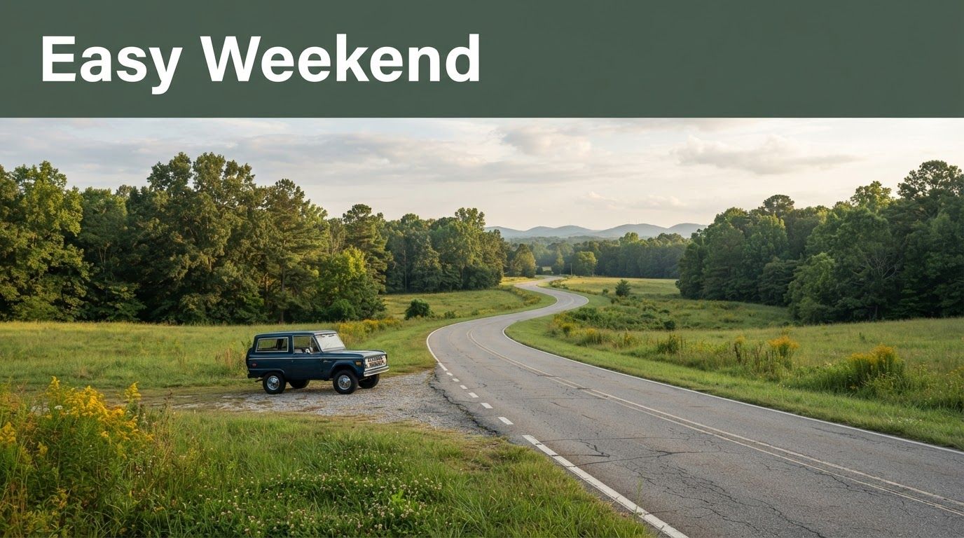 A country road through an Alabama meadow with a parked car and green Easy Weekend banner.