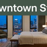 Boutique hotel room with a refined bed, velvet chair, and Nashville skyline view.