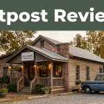 A roadside restaurant with a vintage pickup and a green Outpost Reviews banner at sunset.