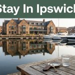 A hotel overlooks Ipswich Marina with historic buildings, reflections, and a room key in front.