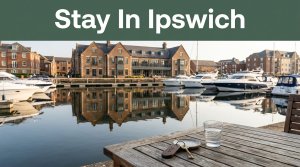 A hotel overlooks Ipswich Marina with historic buildings, reflections, and a room key in front.