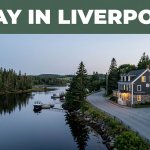A riverside inn glowing beside a quiet road in Liverpool, Nova Scotia.